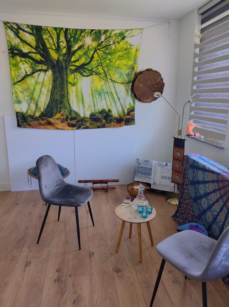 Praktijkruimte van Being in Harmony met wandkleed met een levensboom, klankschalen en een fauteuil